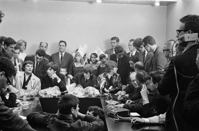 Beatlemania: Fanii și mass-media îi înghesuie pe Beatles la Aeroportul Schiphol din Amsterdam, 1964. Credit foto