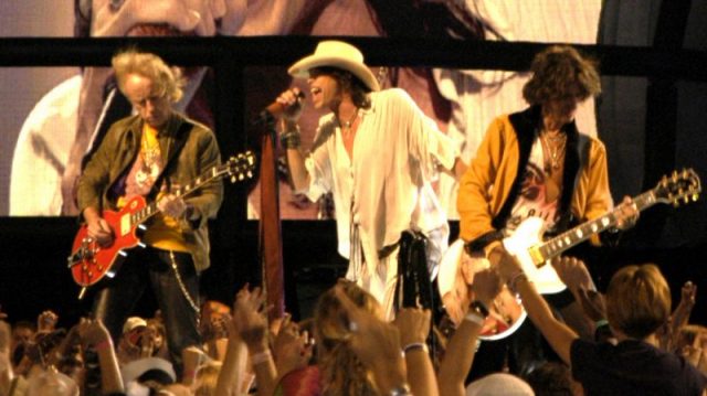 Brad Whitford, Steven Tyler, e Joe Perry dos Aerosmith actuando no Kickoff da NFL em Washington, DC, a 4 de Setembro de 2003.