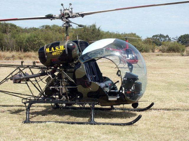 Bell 47G helicopter in MASH colors. (Photo Credit: Nachoman-au / Wikimedia Commons, CC BY-SA 3.0)
