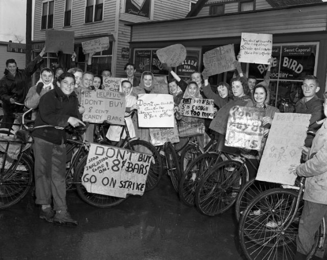 Children holding signs protesting the price of chocolate bars