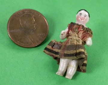 a doll next to a penny