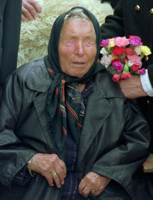 Baba Vanga in a large coat with a scarf over her hair.