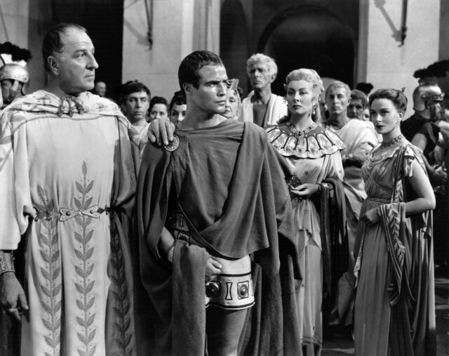 The cast of 'Julius Caesar' standing around in their costumes.