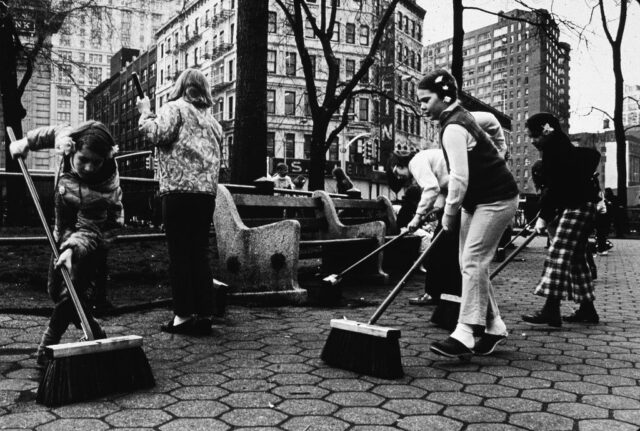 Children sweeping a park area in New York City