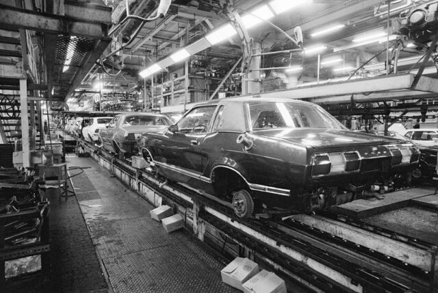 Cars lined up along an assembly line