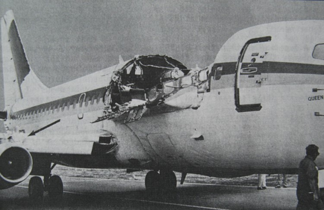 A commercial airplane with part of the fuselage roof missing.