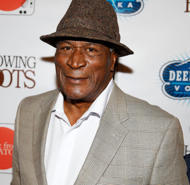 John Amos standing on a red carpet