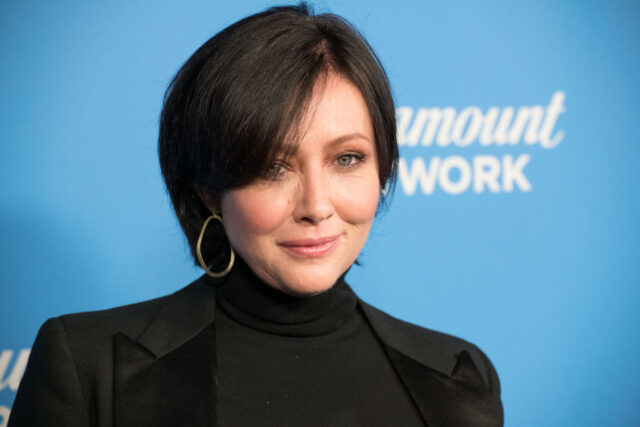 Shannen Doherty standing on a red carpet