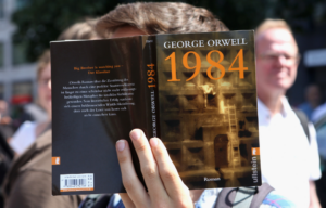 A person holding up the book "Nineteen Eighty-Four"