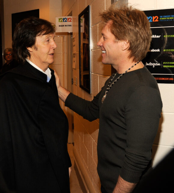 Paul McCartney and Jon Bon Jovi smiling at one another.