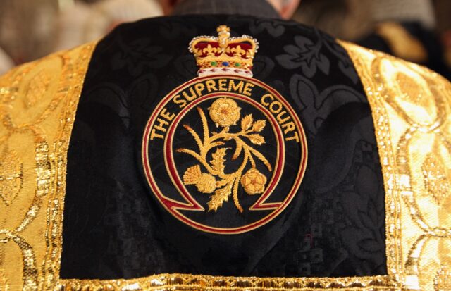 "The Supreme Court" on the back of an ornate robe. 