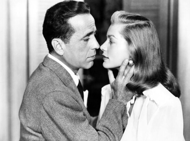 Humphrey Bogart caressing Lauren Bacall's neck.