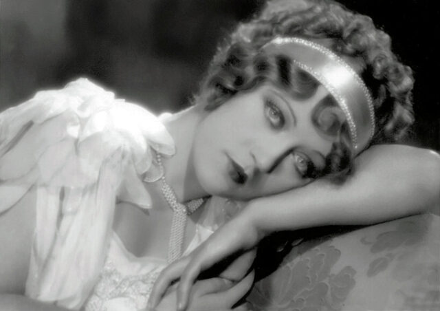 Marion Davies resting on her arm.