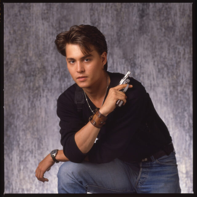 Johnny Depp posing with a handgun.