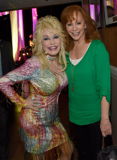 Dolly Parton and Reba McEntire posing for a photo together.