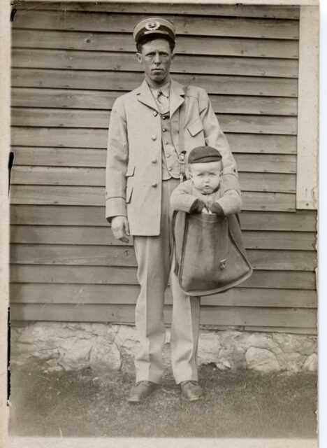 A mailman with a child in his bag.