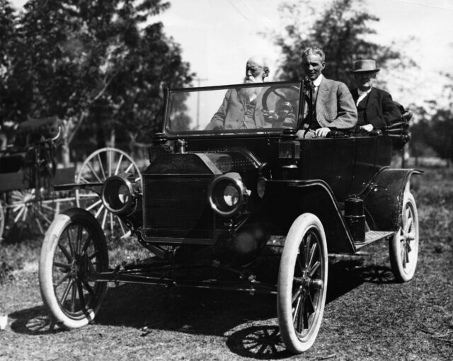 Henry Ford and passengers in a Model T car.