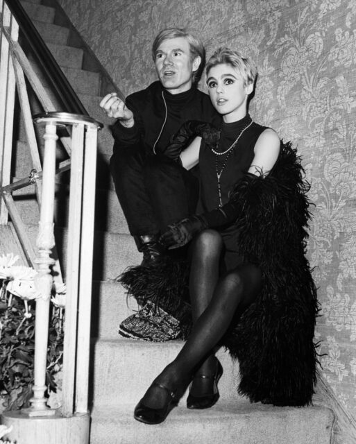 Andy Warhol and Edie Sedgwick sitting on a staircase together