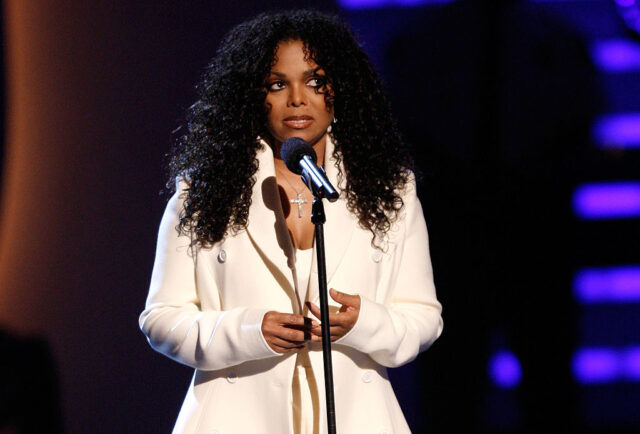 Janet Jackson standing at a microphone on stage