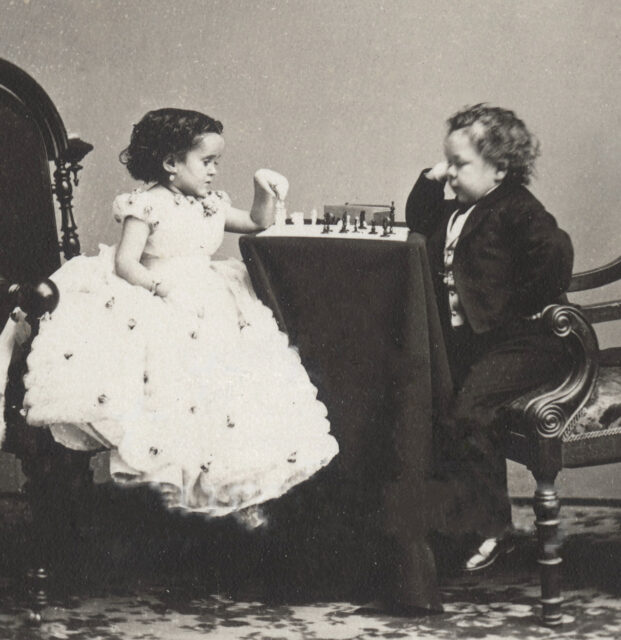 Minnie Warren and Commodore Nutt sitting at a table playing chess.