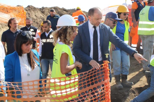 Officials and archaeologists standing together outside