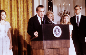 President Nixon at a podium with people around him.