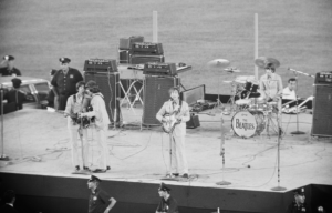 The Beatles performing on an outdoor stage.