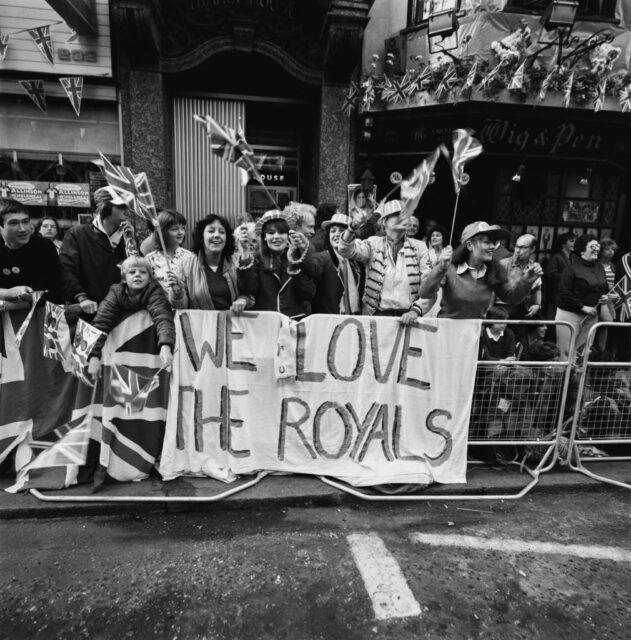 Spectators holding a banner that reads, "WE LOVE THE ROYALS"