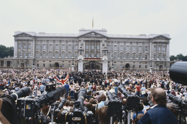 Spectators and media standing outside Buckingham Palace