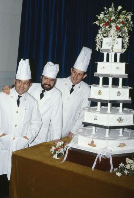 Chief Petty Officer cook David Avery and two others standing with a wedding cake