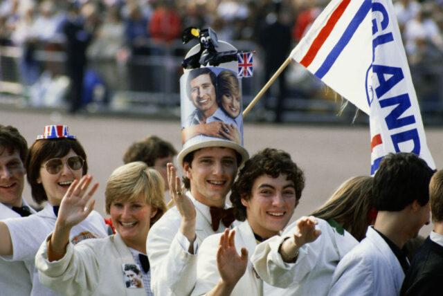 Spectators waving along the side of a street