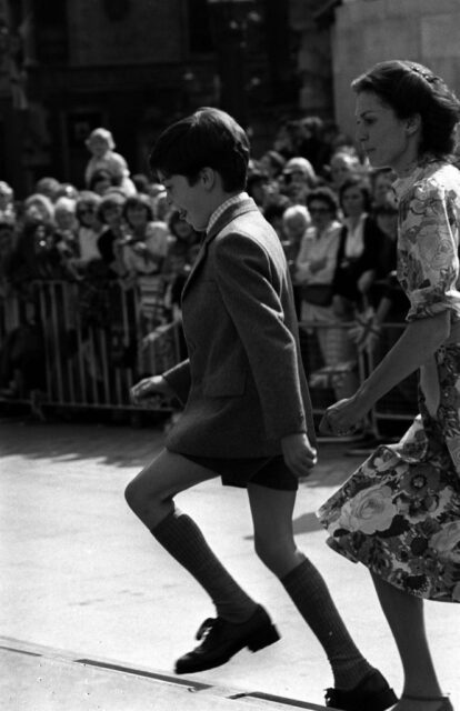 Edward Van Cutsem walking past a crowd of people with a woman