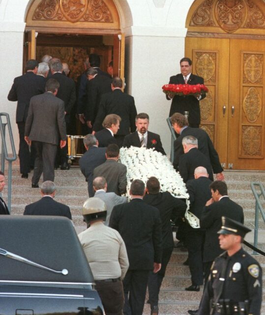 Funeral attendees following Frank Sinatra's casket as it's carried into a church