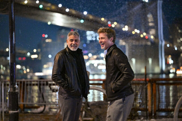 George Clooney and Brad Pitt standing outside at night while it's snowing