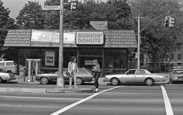 People standing outside of a Dunkin' Donuts.