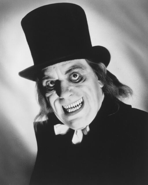 Headshot of Lon Chaney with a spooky face and top hat.