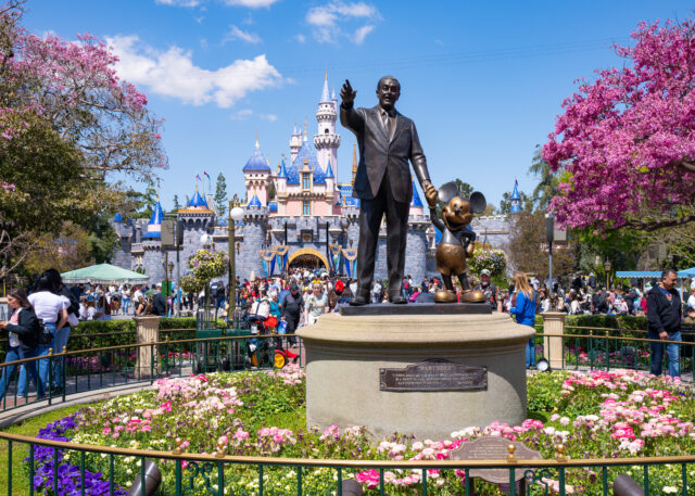 Disneyland guests walking past the Walt Disney "Partners" statue