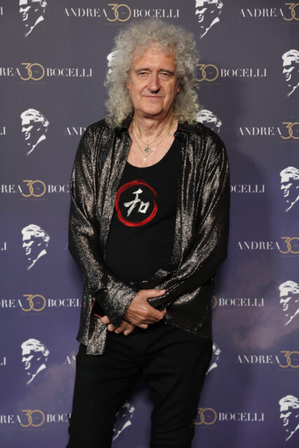 Brian May standing on a red carpet