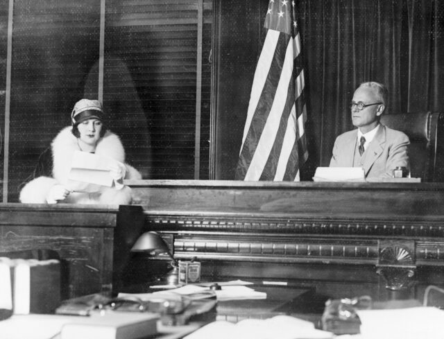 Lita Grey on the stand beside a seated judge.