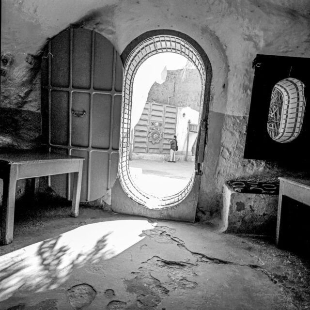 An oval door inside a desert hut.