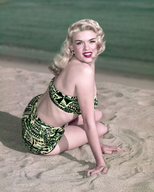 Jayne Mansfield sitting on the beach in a bathing suit