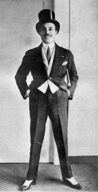 Max Linder standing with his hands in his pockets, wearing a top hat