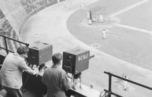 Cameramen capturing a baseball game from a high vantage point.