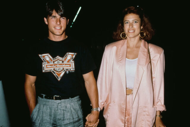 Tom Cruise and Mimi Rogers walking while holding hands