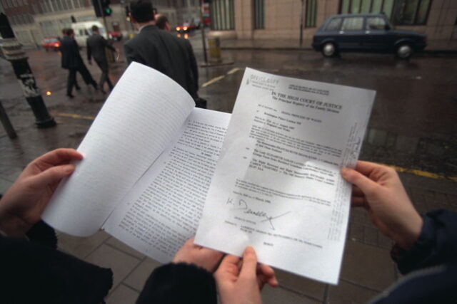 Two people holding the final will and testament of Diana, Princess of Wales