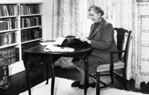 Agatha Christie working at a desk.