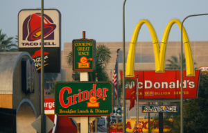 Several fast food signs along a street.