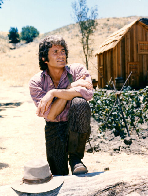 Michael Landon leaning on a post.