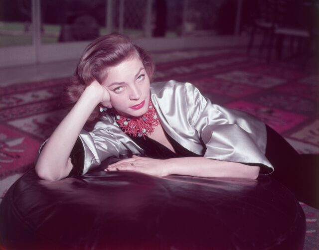 Lauren Bacall leaning on her hand while laying.