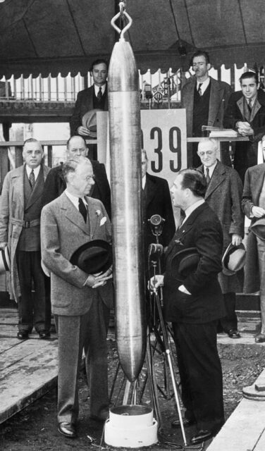 Onlookers watch as a time capsule is lowered into the ground.